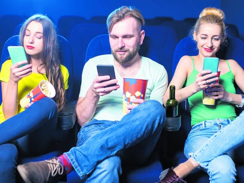 Davanti al grande schermo con un piccolo smartphone