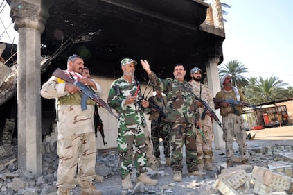Il colonnello Abbas Al Assady con i suoi uomini, volontari di Karbala, la città santa sciita, davanti alla dimora distrutta dell'emiro del Califfato a Jurf al Shakar