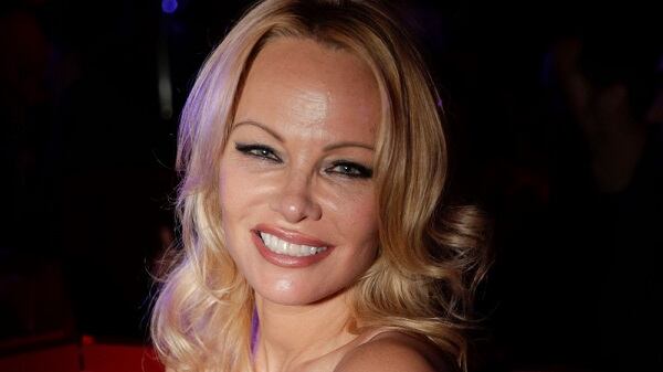Pamela Anderson scatenata, palpa il fidanzato a una première a Parigi