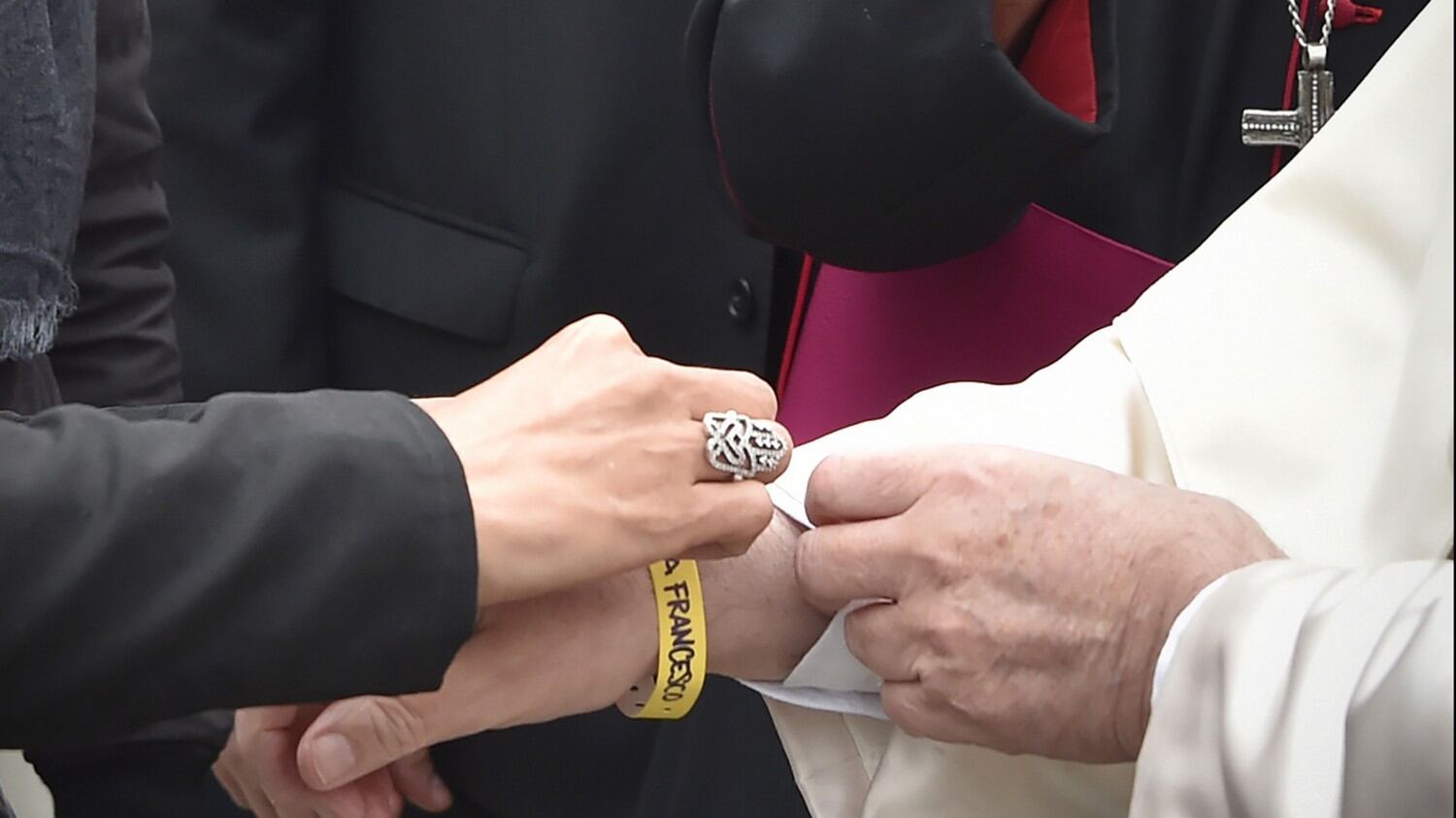 Al papa il bracciale dei migranti. E loro: "Dacci i documenti"