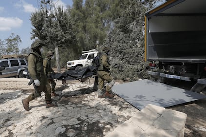 I soldati israeliani radunano e portano via i cadaveri dal kibbutz 3
