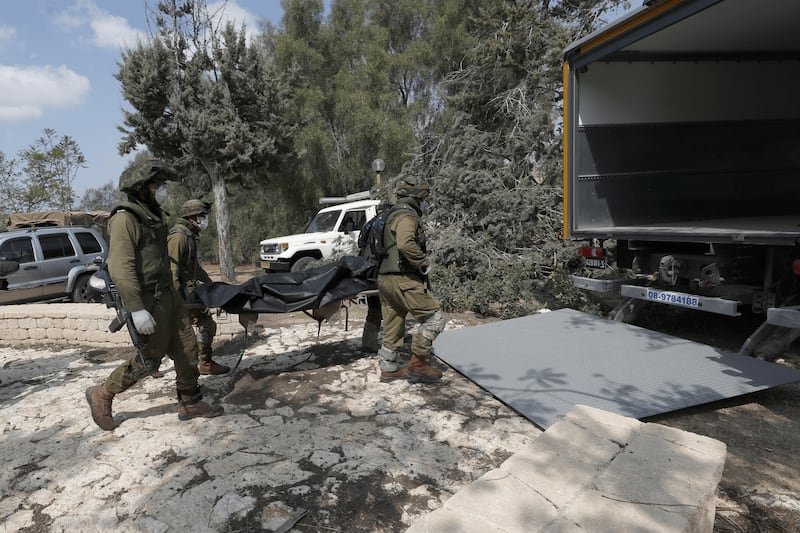 I soldati israeliani radunano e portano via i cadaveri dal kibbutz 3