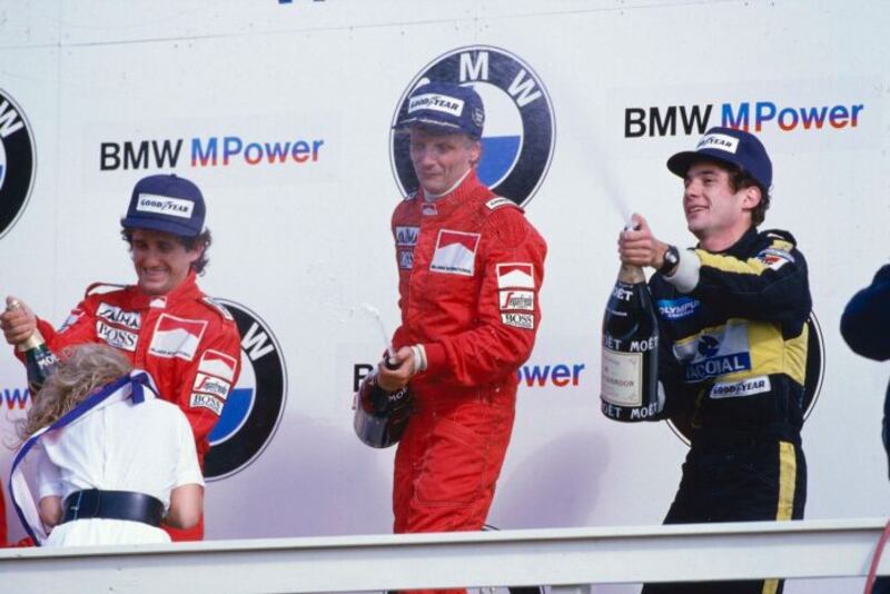 Al centro Niki Lauda festeggia la vittoria con Prost (sinistra) e Senna (destra)