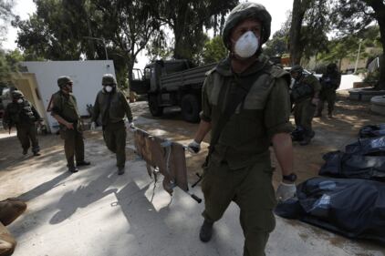 I soldati israeliani radunano e portano via i cadaveri dal kibbutz 4