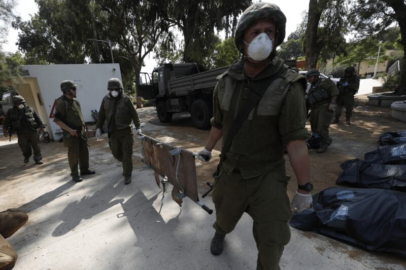 I soldati israeliani radunano e portano via i cadaveri dal kibbutz 4
