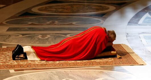 Papa Francesco sdraiato a terra per adorare la croce 1