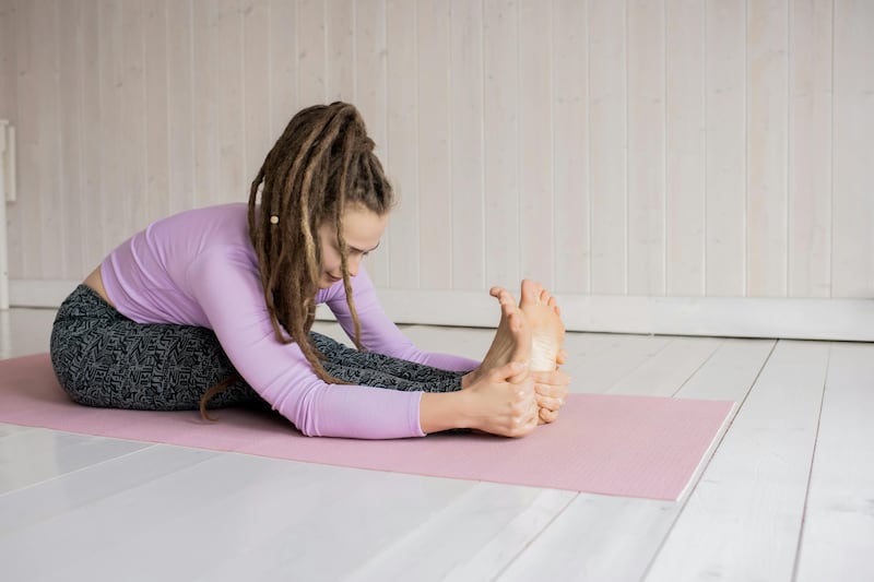 La posizione yoga del piegamento in avanti da seduto (Paschimottanasana)