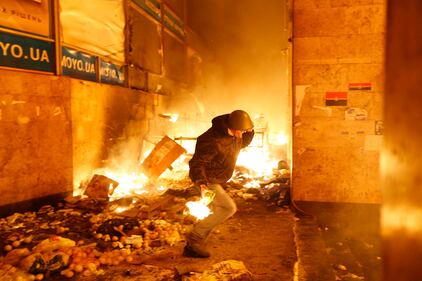 Un manifestante lancia una molotov durante gli scontri a Kiev