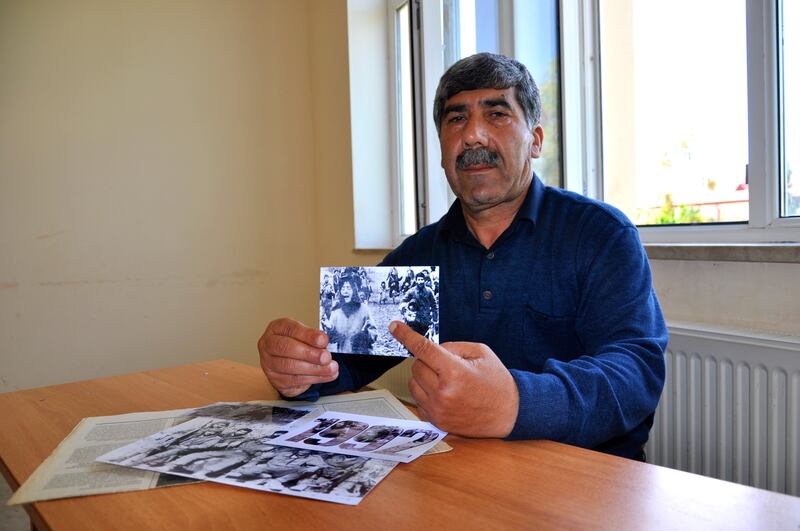 L'ex combattente Oruj Jabbarov con al foto del massacro di Kojali del 1992 quando portò in slavo una bambina