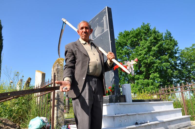 Un contadino mostra le schegge di una granata di mortaio caduta dieci giorni fa nel cimitero del villaggio azero di Gapanli