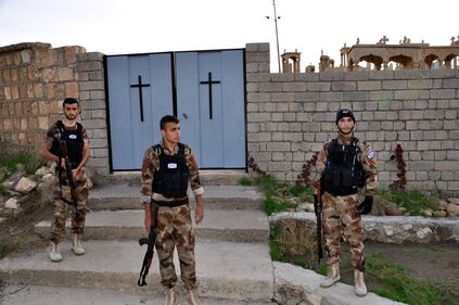 Volontari assiri dvanti al cimitero cristiani