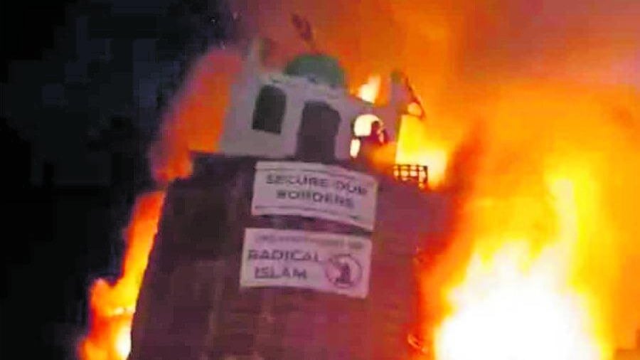 Un protestante brucia il simbolo di una moschea