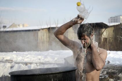 Immigrati bloccati a Belgrado costretti a lavarsi tra la neve 16