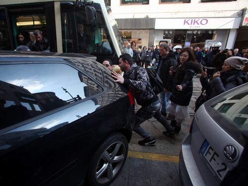 Così la folla sposta di peso l'auto che blocca i binari