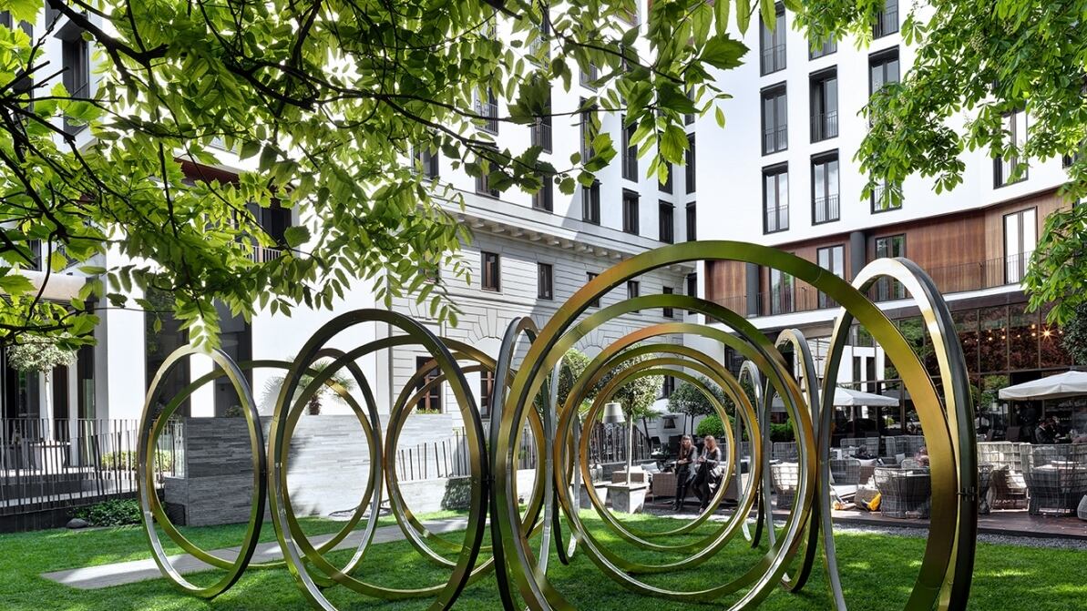 18 anelli in acciaio brillano nel giardino del Bugari Hotel