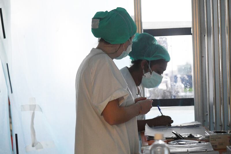 Due operatrici sanitarie lavorano con le mascherine (Fotogramma)