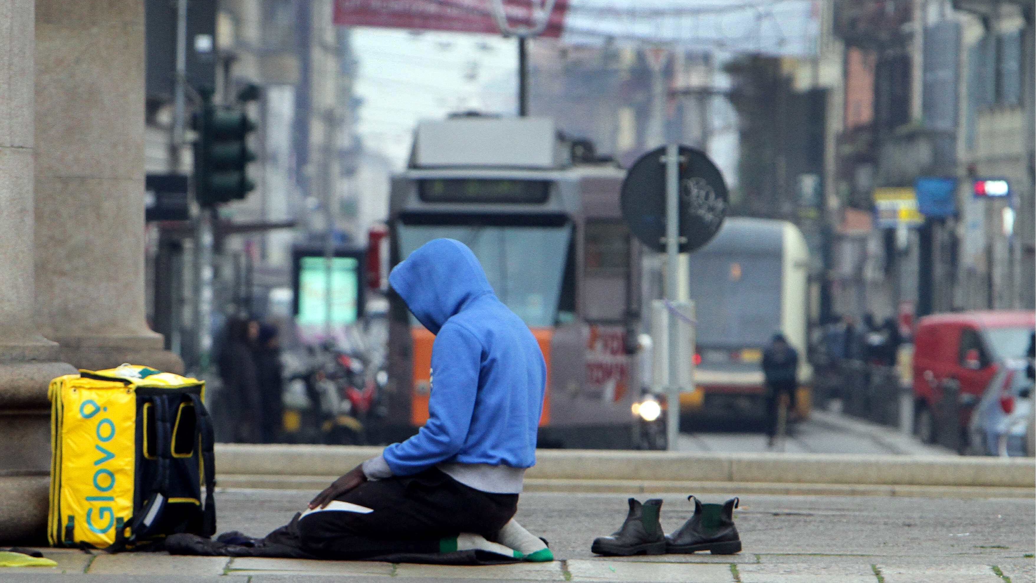 Chini e senza scarpe rivolti alla Mecca: la preghiera islamica dei "riders" del cibo