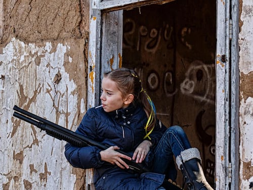 La bambina con il fucile e il lecca lecca. La foto-simbolo (posata) infiamma il web
