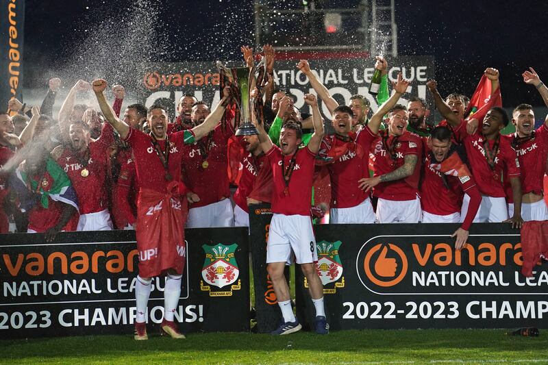 I giocatori del Wrexham alzano in alto il trofeo del campionato vinto lo scorso 22 aprile.