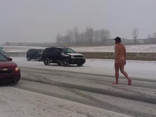Un uomo nudo sotto la neve in autostrada
