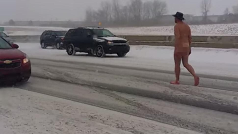 Un uomo nudo sotto la neve in autostrada