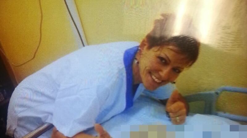 Foto choc, infermiera sorride accanto alla paziente morta