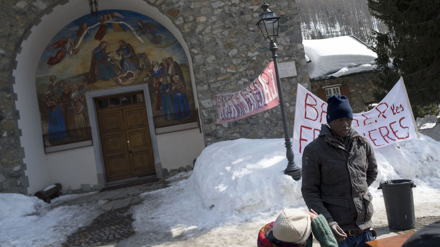 Migranti occupano la chiesa al gelo. Il prete con la scopa: "Andate via"