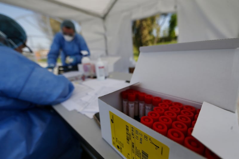 Alcuni operatori esaminano i tamponi (LaPresse)