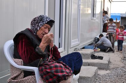 Un'anziana rifugiata cristiana cieca ad Erbil in Kurdistan prega il rosario