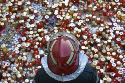 Un pompiere di fronte al memoriale delle vittime del rogo a Bucarest