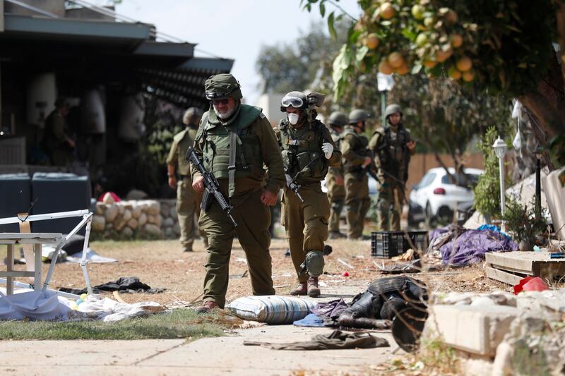 I soldati israeliani radunano e portano via i cadaveri dal kibbutz 1