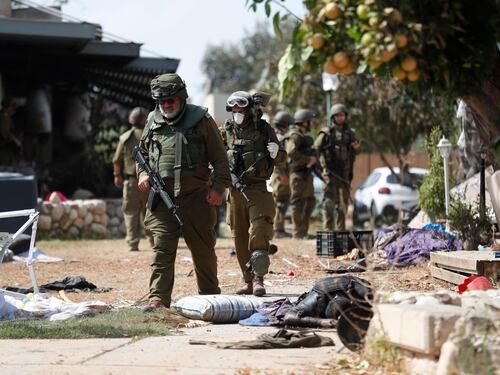 I soldati israeliani radunano e portano via i cadaveri dal kibbutz