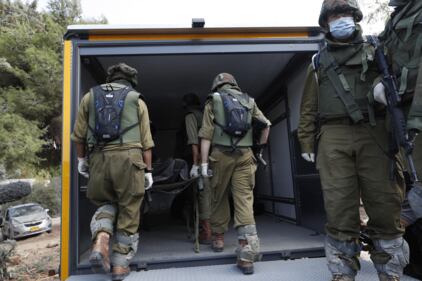 I soldati israeliani radunano e portano via i cadaveri dal kibbutz 2