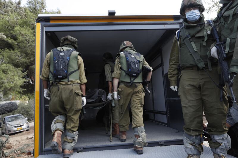 I soldati israeliani radunano e portano via i cadaveri dal kibbutz 2