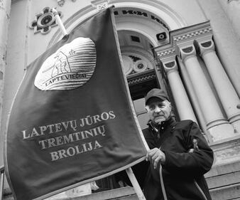 Arūnas Masiulis, nato in Siberia, con la bandiera dei Lapteviečiai, l’associazione dei deportati nel Mar di Laptev, estremo nord della Siberia. La sua famiglia venne deportata dai sovietici, i suoi nonni dagli Zar.