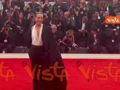 Venezia 82, look sofisticato per Noomi Rapace sul red carpet in pantaloni e soprabito con strascico