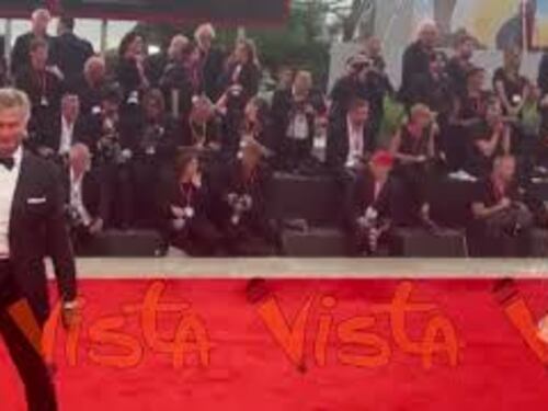 Venezia 82, una modella sfila sul red carpet con un abito decorato da un serpente dorato