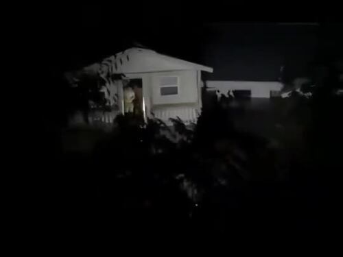 Una casa trascinata via dall'alluvione con le persone dentro