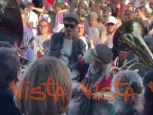 Corteo pro Gaza a Roma, musicisti suonano in strada con bandiere Palestina e kefiah