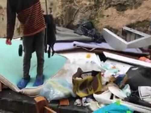Bambina che rovista nella spazzatura a Napoli