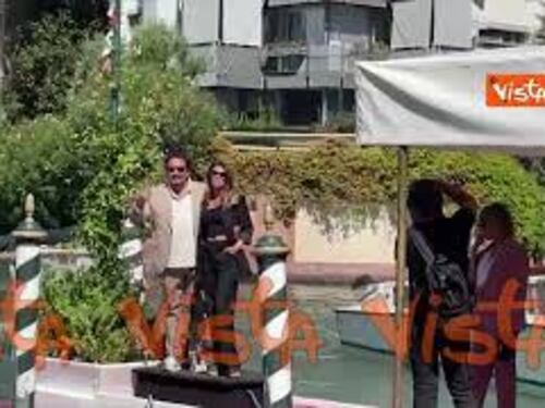 Venezia 80, Brignano e la moglie arrivano al Lido. Il tenero bacio sul molo