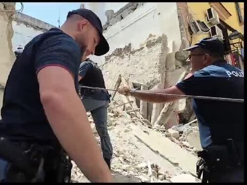 I soccorritori scavano tra le macerie della palazzina crollata