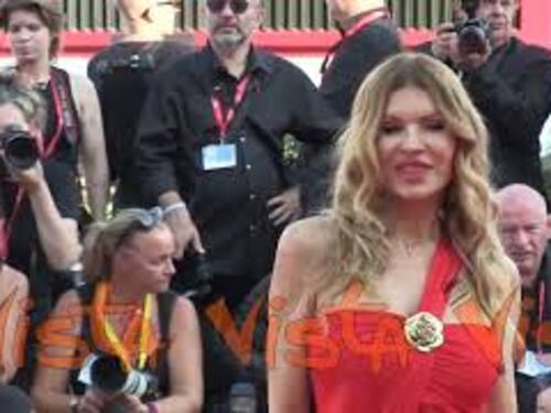 Venezia 81, Rita Rusic sul red carpet con un sensuale abito total red e dettagli oro