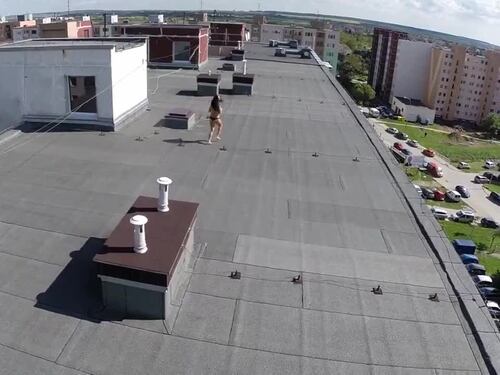 Il drone impiccione riprende la ragazza in topless sul tetto
