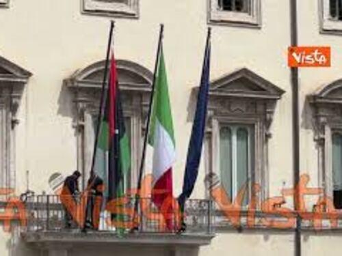 La bandiera libica viene sistemata sul balcone di Palazzo Chigi per la visita del premier Dbeibeh